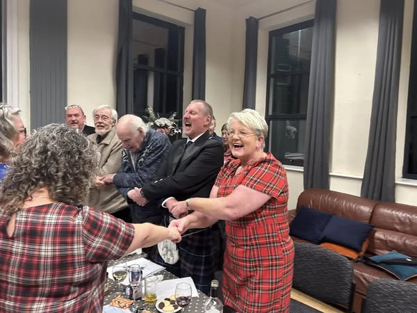 guests dance stood with their arms held around a laid table